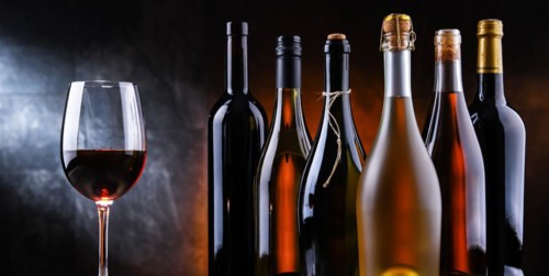 Composition with a wineglass and bottles of different sorts of wine