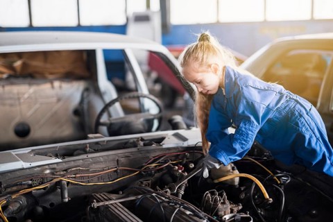 Little girl repairing car with spanner