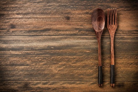 Wooden spoon and fork on rustic wooden table with copy space for your text