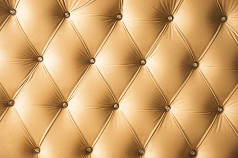 Beige soft textile background with symmetrical buttons on the corners of diamonds. Soft and