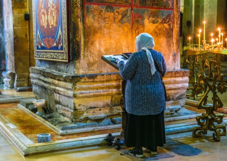 MTSKHETA, GEORGIA - OCT 25, 2018: Woman praying in Svetitskhoveli Cathedral in the historic town of