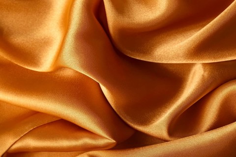 Texture of orange silk fabric, close up