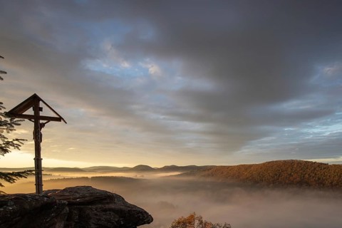 Mystical sunrise at the Wachtfelsen. Fascinating landscape shot between fog and clouds near