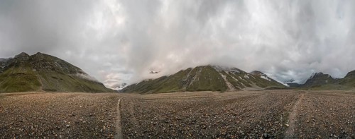 Panoramic view of hiking trail in glacial valley high up in Kashmir mountains in India on cloudy
