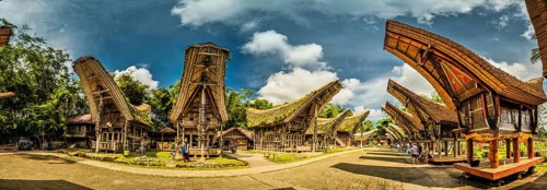 Sulawesi, Indonesia, May 2015: Panoramic photo of tongkonans with saddleback roofs and small square