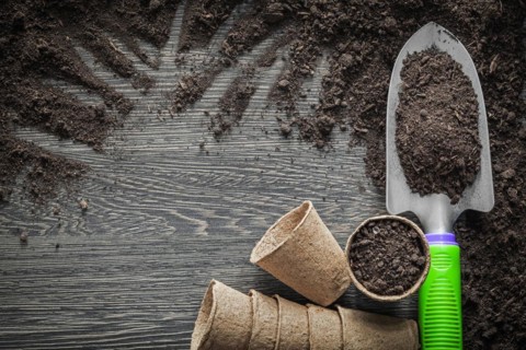 Peat pots soil shovel on wooden board