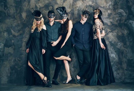 Group of people in masquerade carnival mask posing in studio. Beautiful women and men wearing