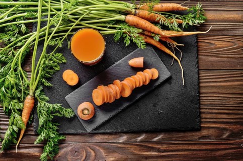Top view at fresh organic vegetarian carrot juice on wooden kitchen table