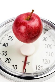 An apple lies on a bathroom scales. Symbolic photo for weight loss and a healthy, vitamin-rich diet