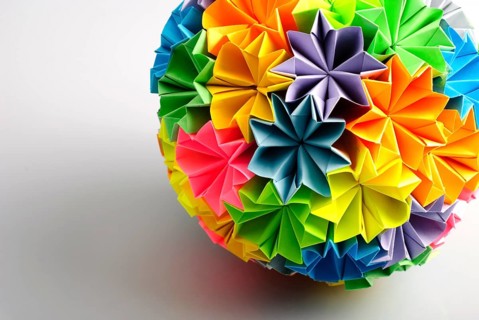 Colorfull origami kusudama from rainbow flowers isolated on white. Close-up with shadow
