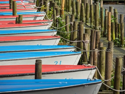 Several boats in red and blue moored at a jetty in the harbour, Bad Zwischenahn, ammerland, germany