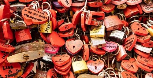Verona, Italy, June 2022: background of heart-shaped locks on a wall, symbol of love forever