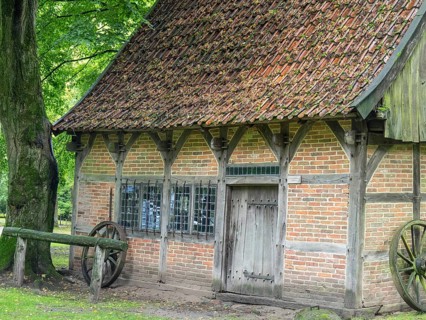 Old half-timbered house with tiled roof, surrounded by trees and nature, Bad Zwischenahn,