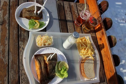 Eating fried fish outside, winter at the Baltic Sea