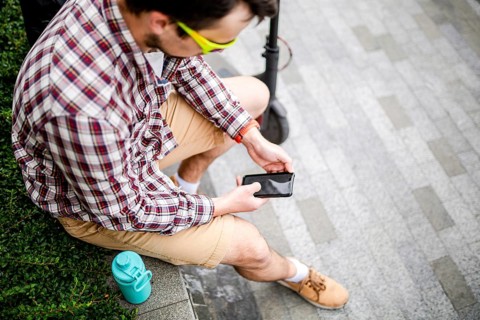 Caucasian man uses modern technologies Internet and cellular communication on smartphone while