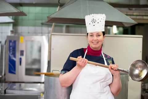 May 31, 2021 Belarus, Gomel, industrial kitchen. Chef in an industrial kitchen smiling and looking