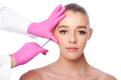 Beautiful face crows feet injection Cosmetic skincare spa beauty treatment with pink gloves by eye,