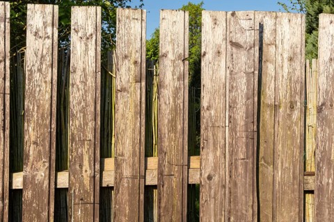 Borken, NRW, Germany, Sunlight illuminating old wooden fence protecting garden in summer