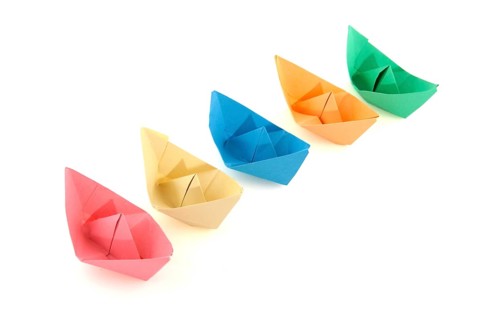 Colorful folder paper boats isolated over white