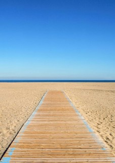 Wooden pathway leading to the beach and sea. Summer scene with clear blue sky