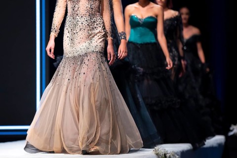 Female models walk the runway in beautiful designer dresses during a Fashion Show. Fashion catwalk
