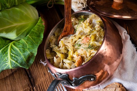 Junger und frischer kohl, gekocht mit speckwürfeln