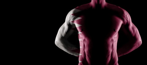 Qatar flag on muscled male torso with abs, black background