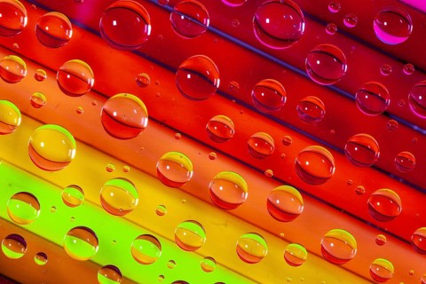 Color pencils under glass with drops of water. Office concept