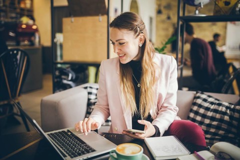 Business woman freelance working on computer notebook laptop and mobile phone, with coffee cup on