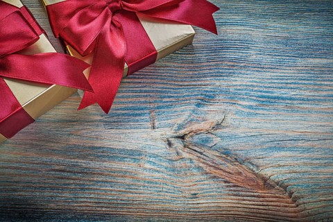 Gift boxes with tied bows on vintage wooden board holidays concept