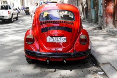Red Volkswagen Beetle on a city street, Cuba, Greater Antilles, Caribbean, Central America, America
