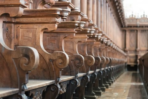 Cathedral choir stalls made of wood. Row of wooden choir stalls