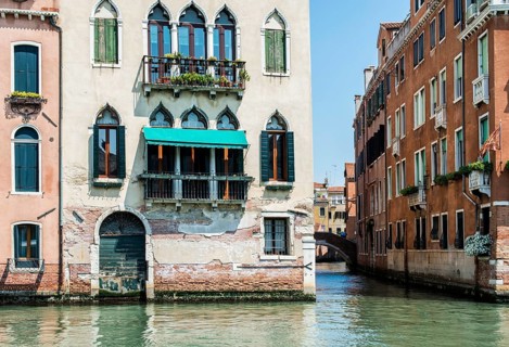 Ancient buildings in Venice. Boats moored in the channel. View from the side of the water