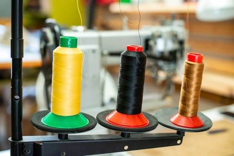Threads and sewing machine in tailor shop. Close up