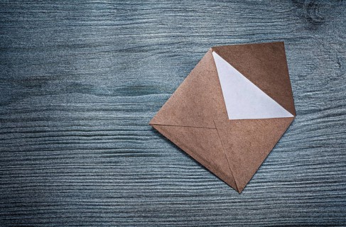Vintage opened envelope with message on wooden board