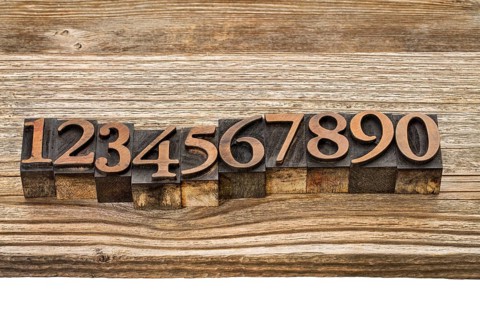 Number abstract in vintage letterpress wood type against grained wooden plank