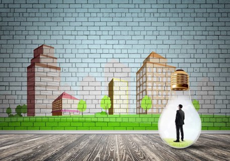Businessman inside light bulb against city drawn concept