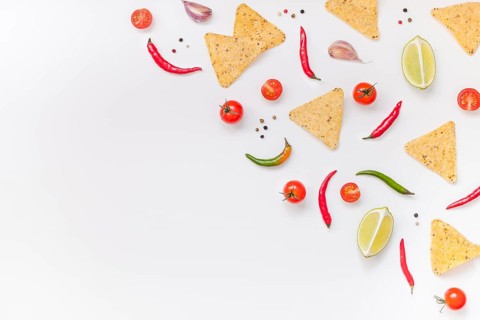Creative Top view flat lay of fresh mexican food ingredients with tortilla nachos chips garlic