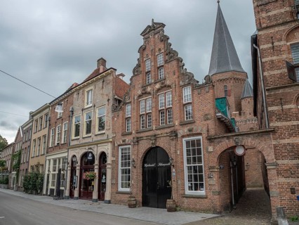 Historic houses and a church tower in a quiet street under a cloudy sky, zutphen, gelderland,