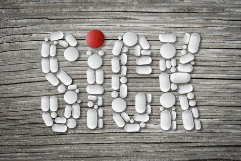 Conceptual Health Image Of Pills On A Wooden Table Spelling The Word Sick