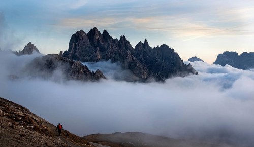 Unrecognised man trekking late in the evening at the hikking path of the picturesque Dolomites at