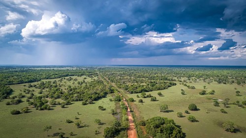 Aerial view of Transpantaneira dirt road with dramatic sky and rain crossing the typical landscape