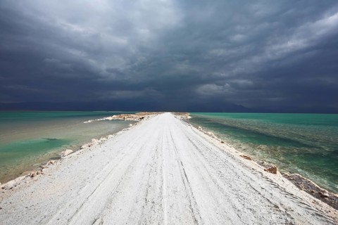 Sunset. Incredible lighting effects in a thunderstorm at the Dead Sea. The road in the middle of