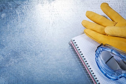 Safety glasses gloves copybook on metallic background