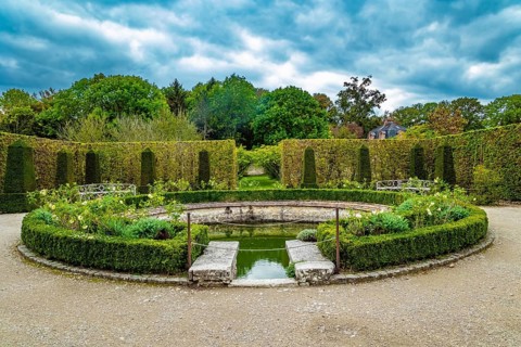 Picturesque round pool in the park greenhouse. Thepossession of Puss in Boots. Graceful bosquets