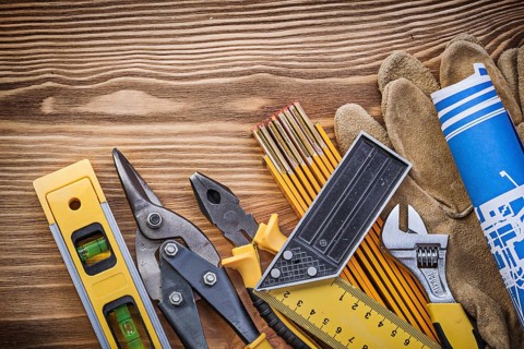 Heap of construction tooling on vintage wooden board