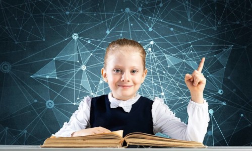 Smiling little girl sitting at desk with open book. Research and education in school. Happy
