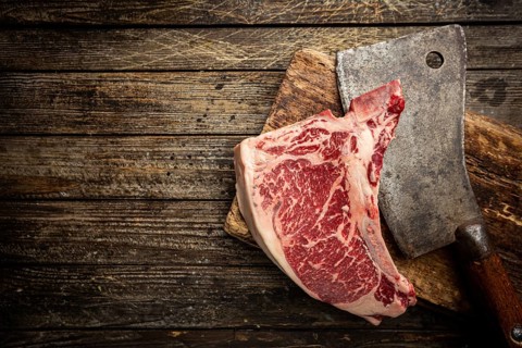 Raw fresh meat T-bone beef Steak and butcher knife on wooden background, top view