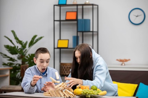 Eine Gruppe von Kindern ist mit einem spannenden Jenga-Spiel beschäftigt, bei dem sie ihre