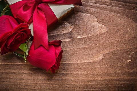 Wrapped present with red ribbon natural bloomed roses holiday concept